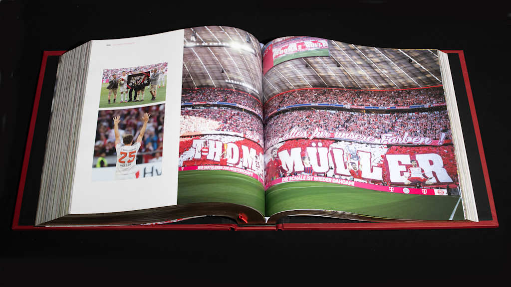 Eine Doppelseite des FC Bayern Opus Buches wird gezeigt: Mit Thomas Müller.