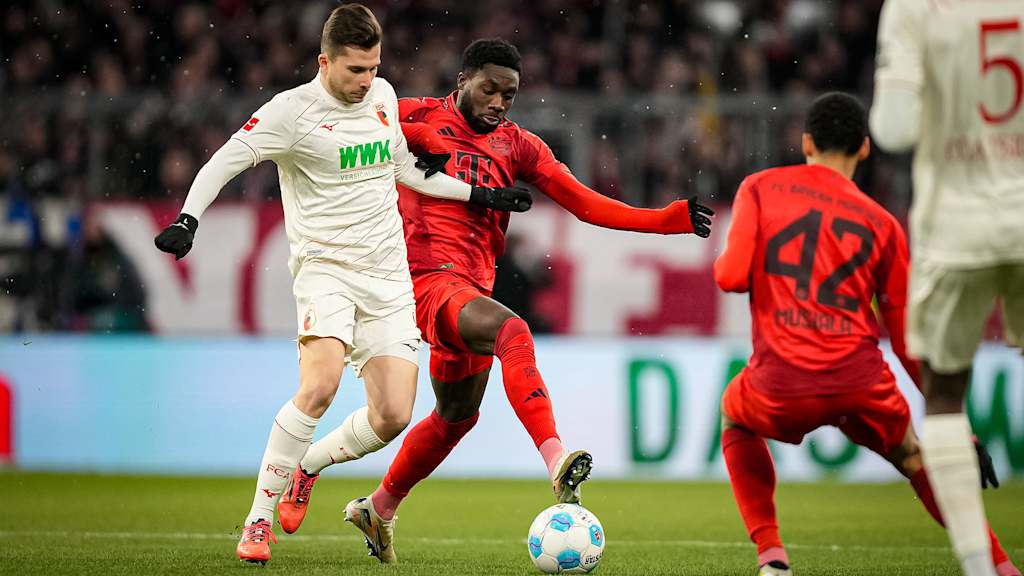 Alphonso Davies, vestido de rojo, en un duelo con un jugador del Augsburg.