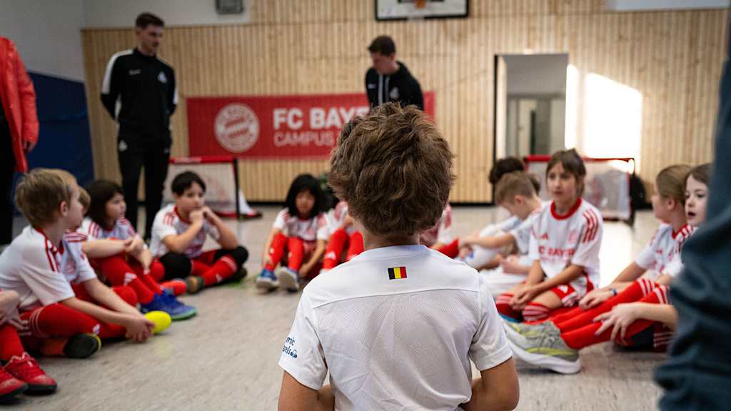 Teilnehmer des FC Bayern Campus Training an einer Münchner Schule sitzen im Kreis
