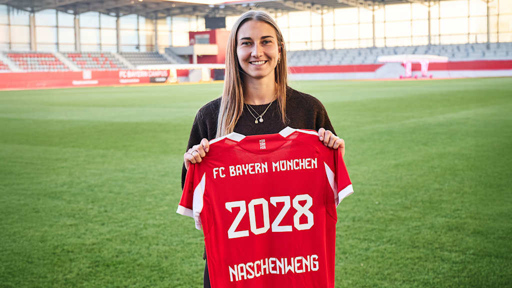 Katharina Naschenweng hält ihr Trikot mit ihrer neuen Vertragslaufzeit in den Händen.