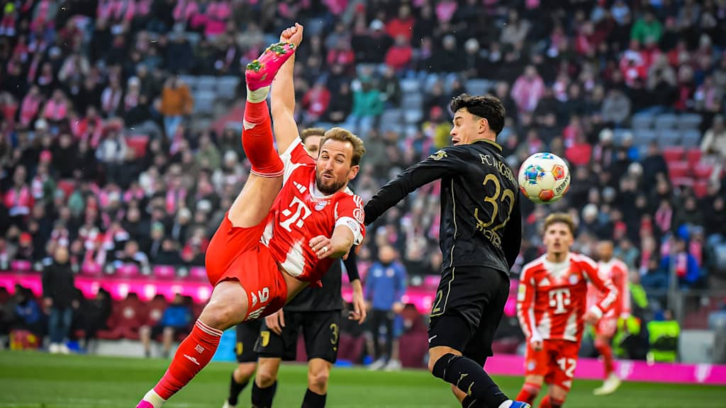 Harry Kane mit einem Fallrückzieher Aleksandar Pavlović beim Abschluss während des Heimspiels des FC Bayern in der Bundesliga gegen den FC Augsburg