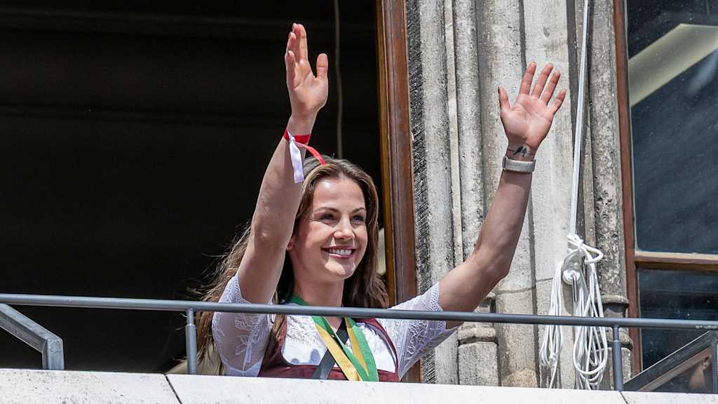 Tuva Hansen streckt beide Hände empor und lächelt auf der Meisterfeier am Rathausbalkon.