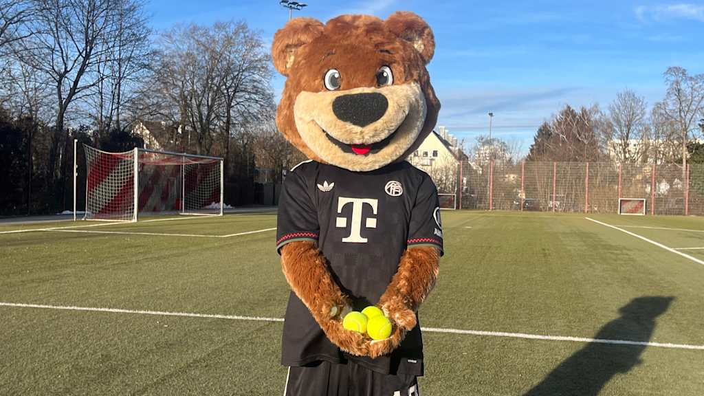 Berni aud dem Kunstrasenplatz mir drei Tennisbällen in den Händen.