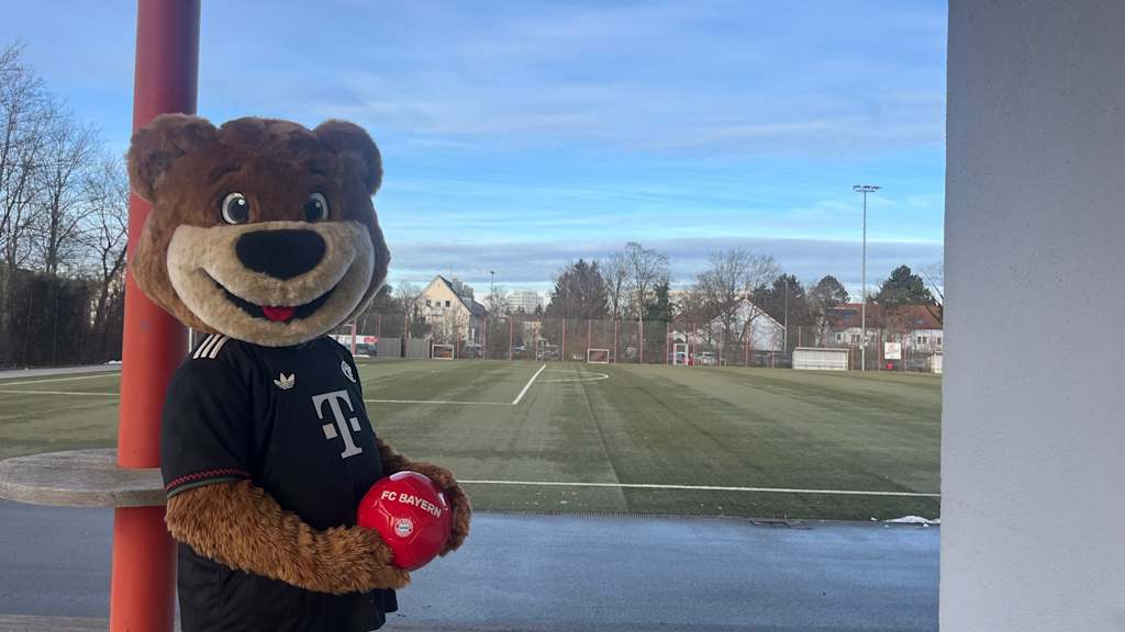Berni steht vor einer Wand mit dem Ball in der Hand.