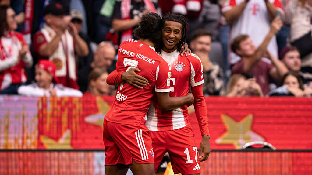 Michael Olise und Serge Gnabry umarmen sich nach dem 1:0 im Bundesliga-Spiel FC Bayern gegen Hamburger SV.