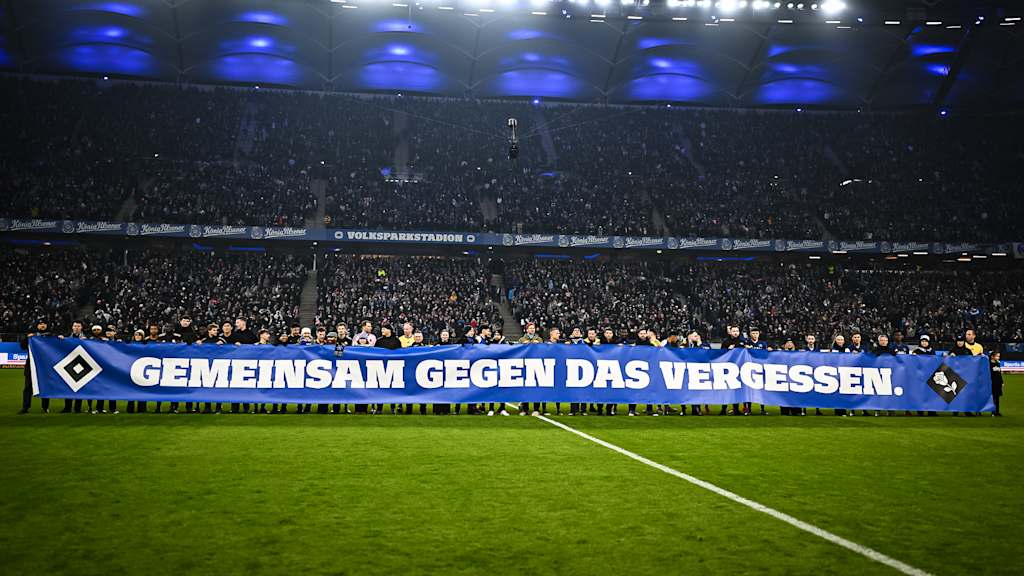 Spieler und Mitarbeiter beider Vereine halten ein Banner vor dem Gastspiel des FC Bayern in der Bundesliga beim Hamburger SV