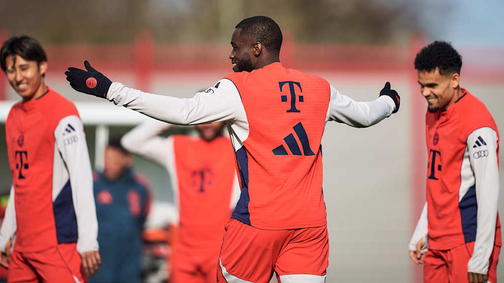 Dayot Upamecano mit ausgebreiteten Armen lächelnd mit den Teamkollegen im Abschlusstraining des FC Bayern vor dem Gastspiel in Bremen