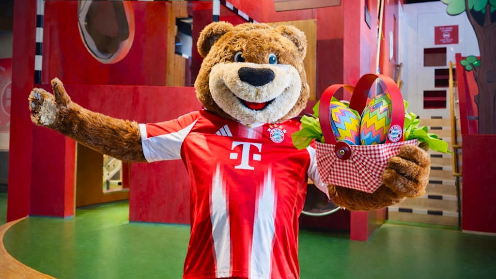 Maskottchen Berni posiert mit Osterkorb im FC Bayern Museum