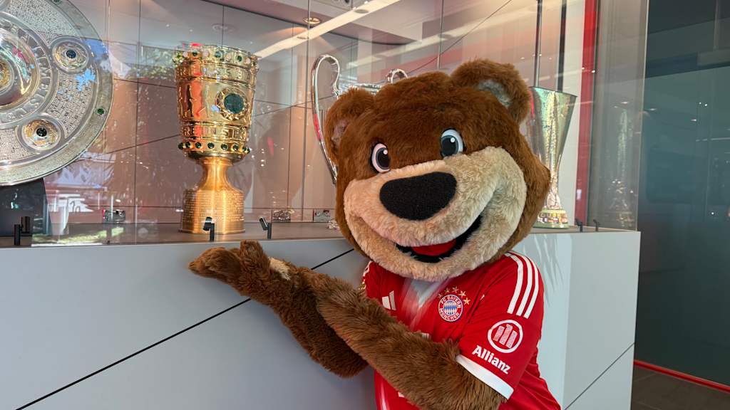 Berni vor den Pokalen des FC Bayern.