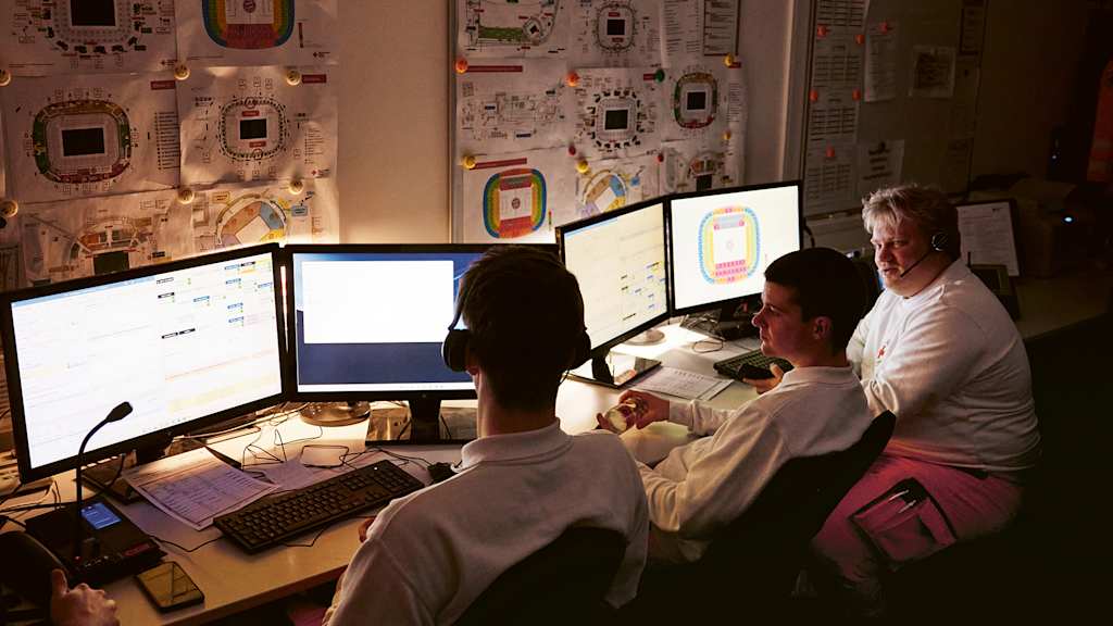 Rettungssanitäter schauen während eines Spiels des FC Bayern in der Allianz Arena auf einen Bildschirm