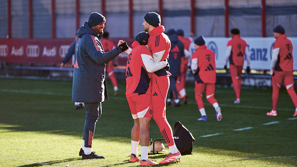 Vincent Kompany schlägt lachend mit Leon Goretzka während des Trainings ein
