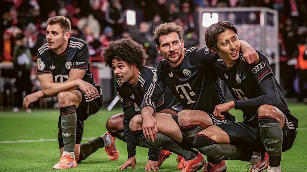 Josip Stanisic, Serge Gnabry, Leon Goretzka und Hiroki Ito hockend vor der Fankurve des FC Bayern