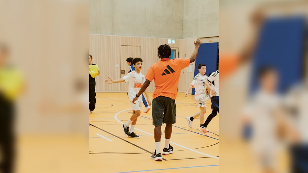 Wisdom Mike klatscht mit einem kleinen Jungen ab.