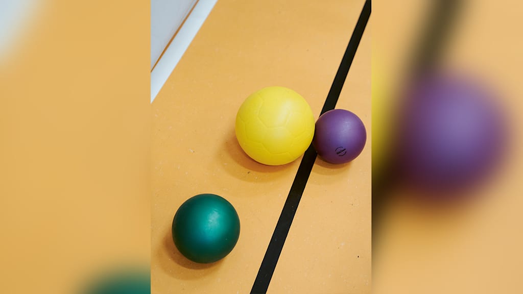 Bälle liegen auf den Turnhallenboden.