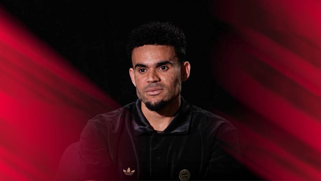 Michael Olise in einem schwarzen Oberteil blickt nach vorne.