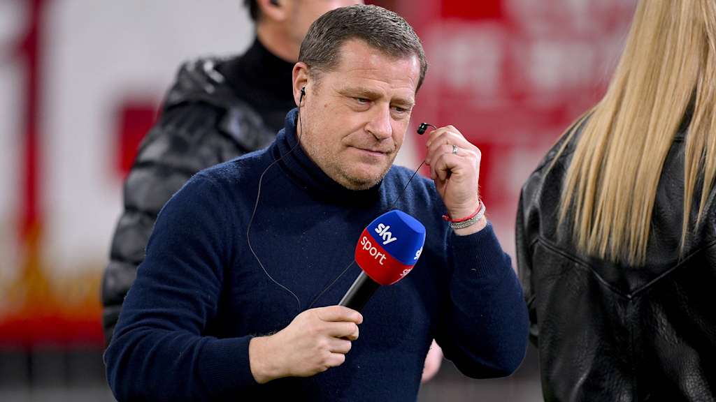 Max Eberl bei einem Fernsehinterview mit Mikrofon in der Hand