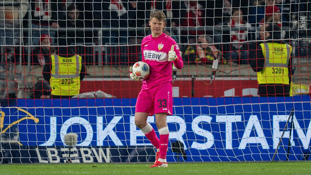 Alexander Nübel hält den Ball, grinst und zeigt einen Daumen nach oben.