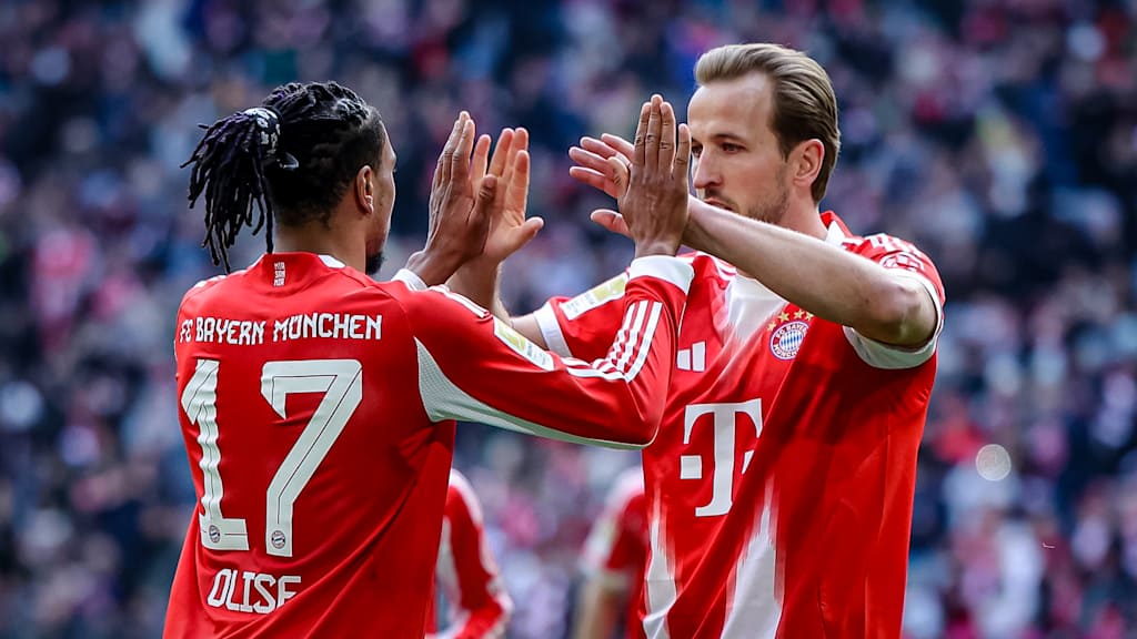 Harry Kane und Michael Olise klatschen ab während des Heimspiels des FC Bayern in der Bundesliga gegen den 1. FC Union Berlin