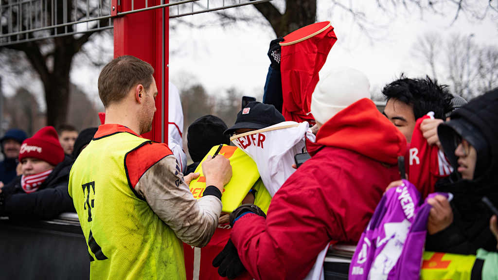 Manuel Neuer unterschreibt ein Trikot eines Fans