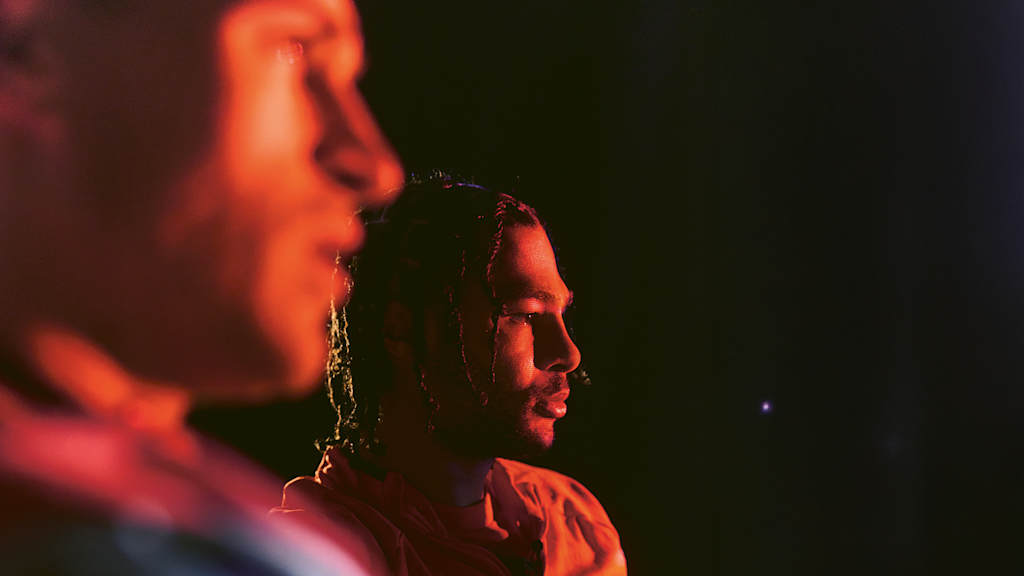 Serge Gnabry neben Joshua Kimmich in einem dunklen Raum vor einem Bildschirm