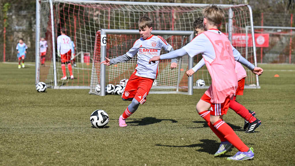 Jugendliche in FC Bayern Campus-Training-Shirts beim Fußballspielen