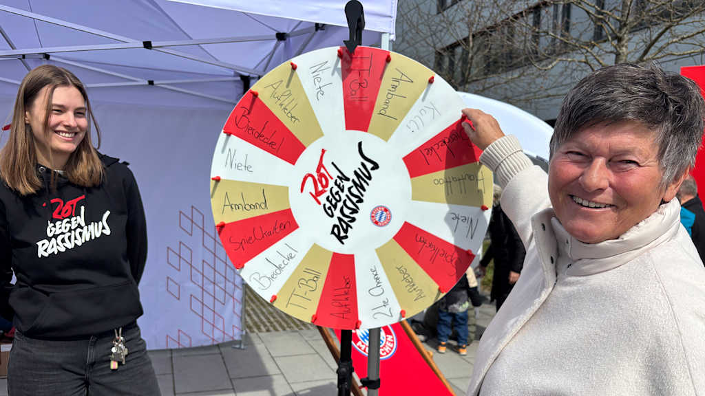 Karin Danner dreht an einem Glücksrad mit Rot gegen Rassismus Logo