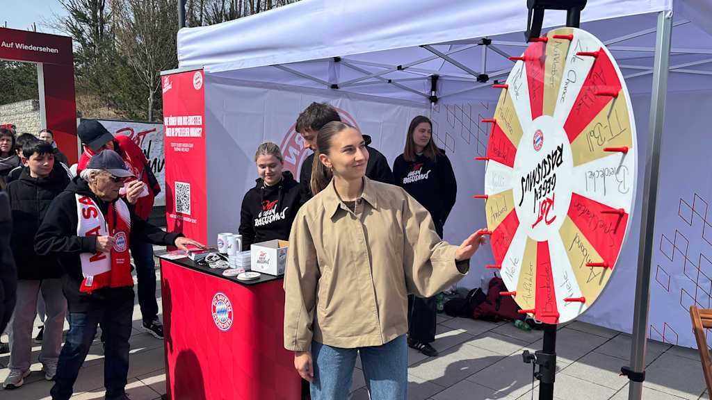 Katharina Naschenweng dreht an einem Glücksrad mit Rot gegen Rassismus Logo