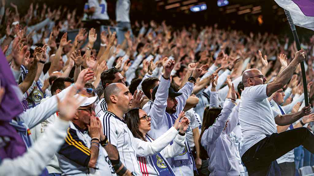 Fans von Real Madrid im Bernabeu heben die Hände und singen