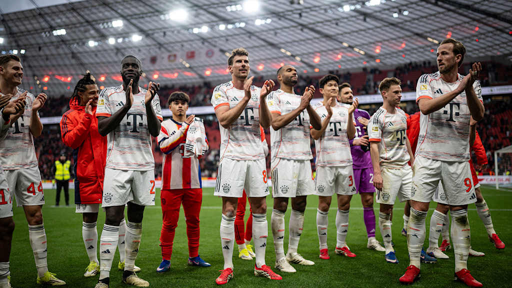 Spieler des FC Bayern feiern nach dem 1:1 in Leverkusen vor der Fankurve