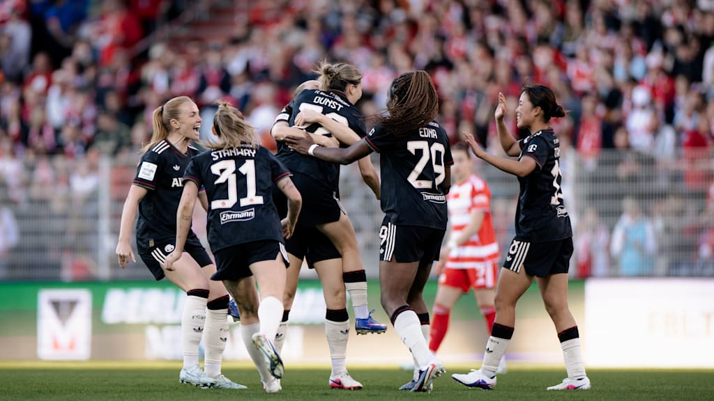 Die Spielerinnen vom FC Bayern liegen sich in den Armen und bejubeln einen Treffer.