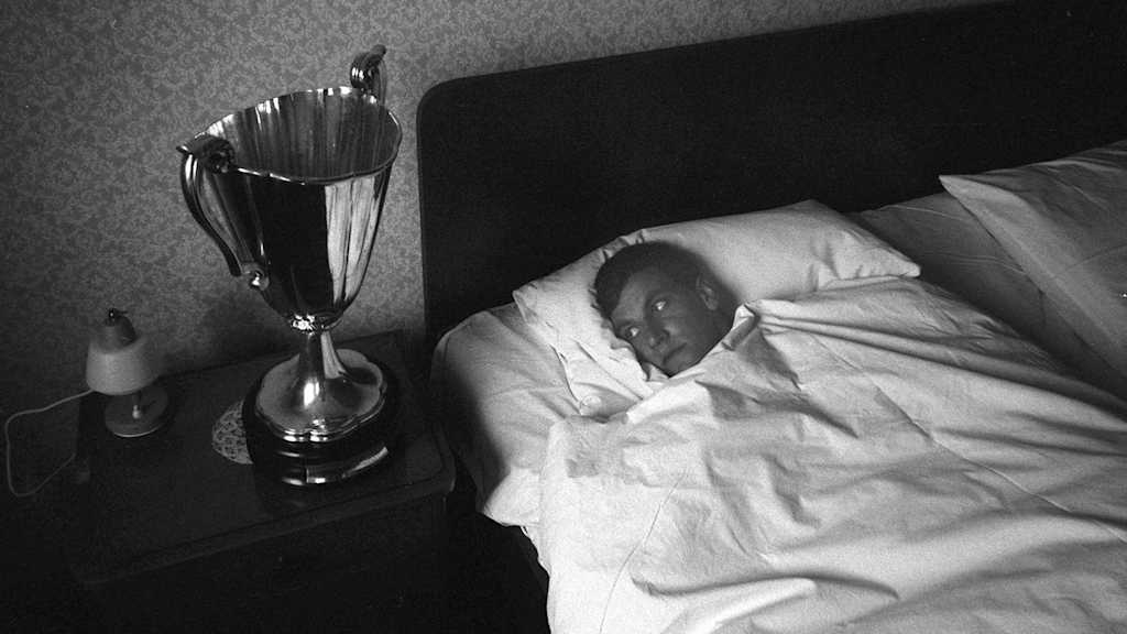 Franz Roth liegt im Bett, neben ihm auf dem Nachtisch der Europapokal der Pokalsieger