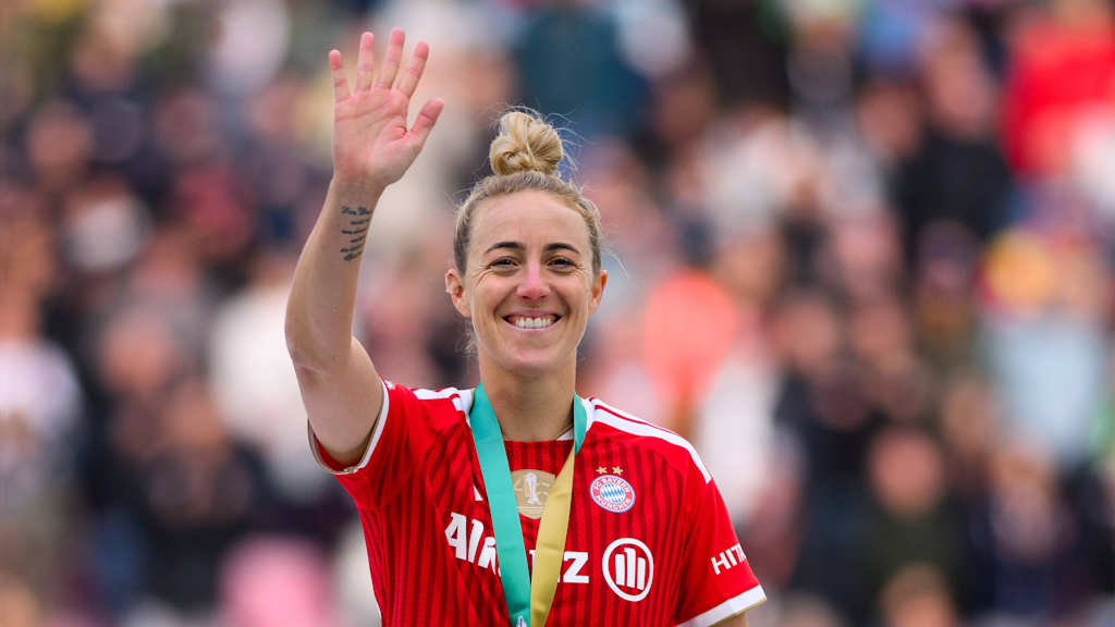 Carolin Simon winkt mit einem Lächeln und der DFB-Pokal-Goldmedaille um den Hals in Richtung Kamera.