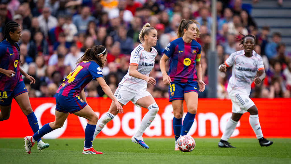 Giulia Gwinn dribbelt am Ball, umgeben von Bonmati und Putellas.