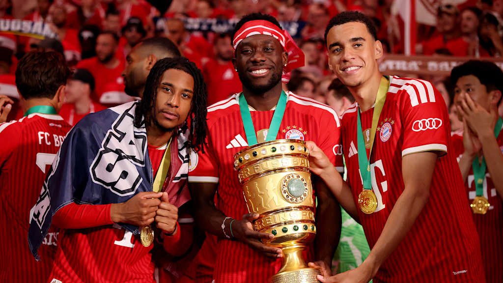 Michael Olise, Alphonso Davies und Jamal Musiala jubeln nach dem Triumph des FC Bayern im DFB-Pokal-Finale gegen den VfB Stuttgart.