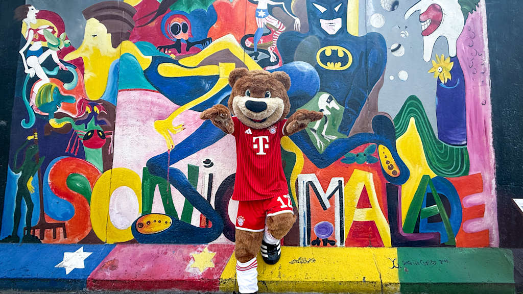 Berni steht vor einem bunten Kunstwerk der East Side Gallery.