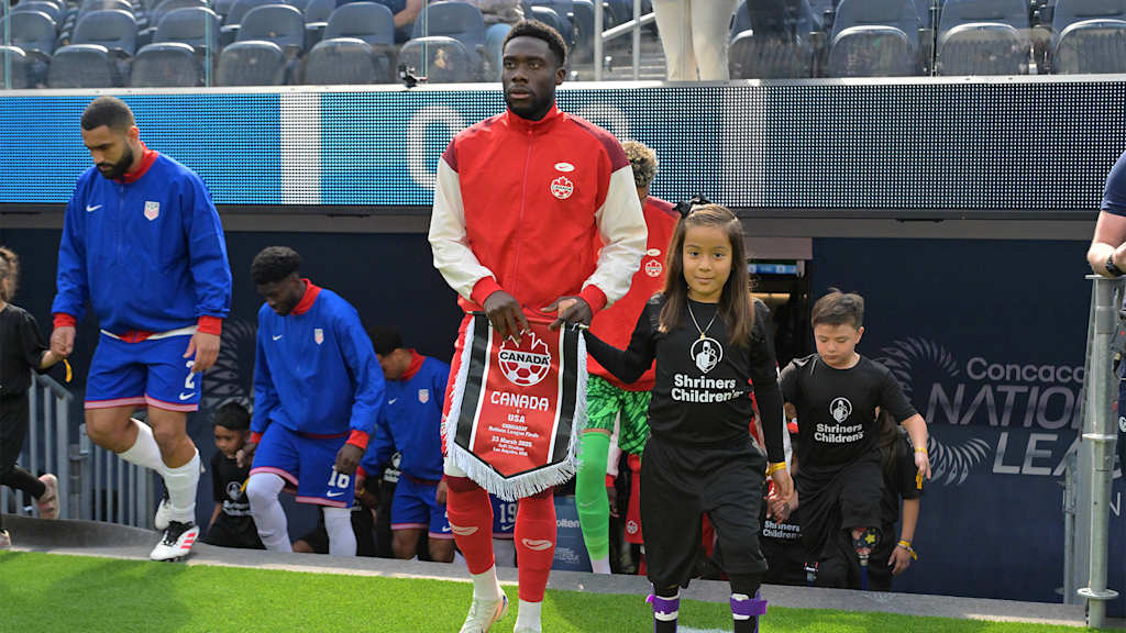 Kanadas Kapitän Alphonso Davies mit Wimpel in der Hand betritt den Rasen vor dem Länderspiel gegen die USA.