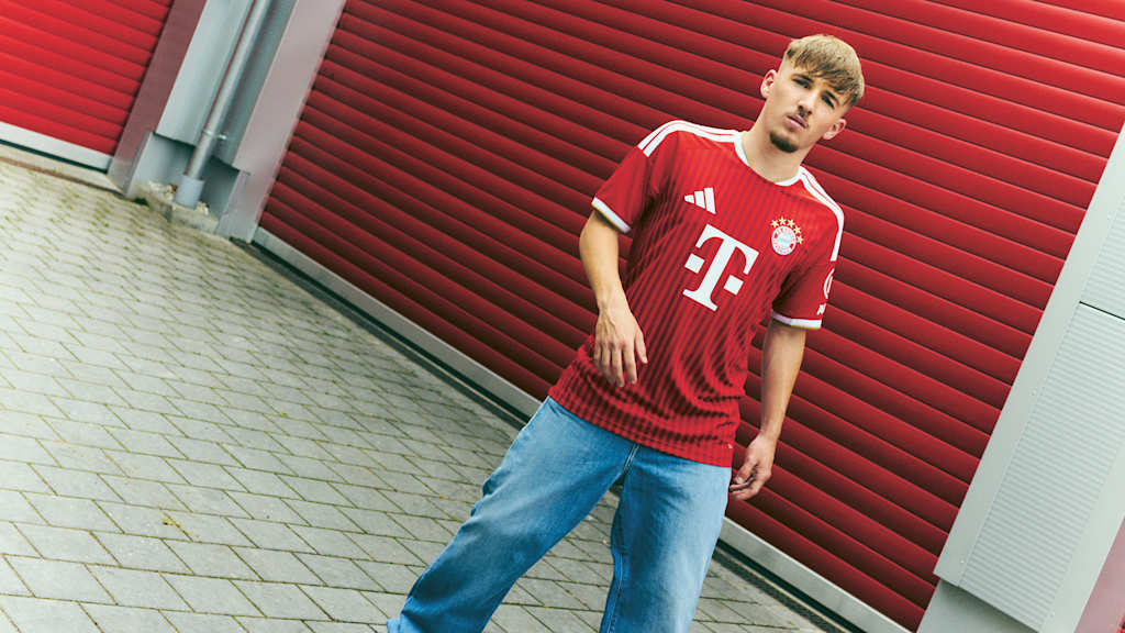Lennart Karl steht im FC Bayern Trikot vor einem roten Tor