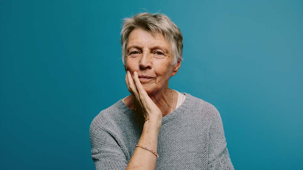 Inge Mayerhofer vor blauem Hintergrund.
