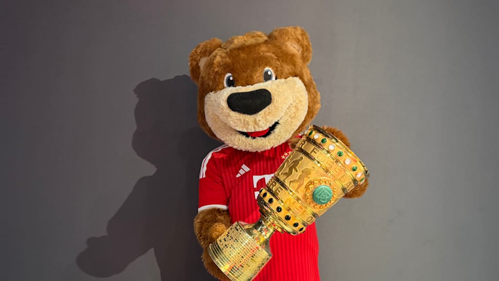 Berni steht mit dem DFB-Pokal vor einer Wand