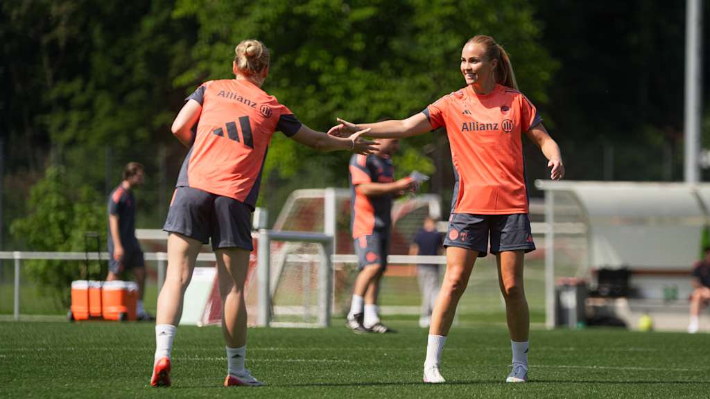 Franziska Kett and Glódís Perla Viggósdóttir high-five each other during training