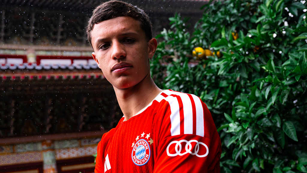 Heitor Almeida steht im roten FC Bayern-Jersey vor einem Tempel in Südkorea