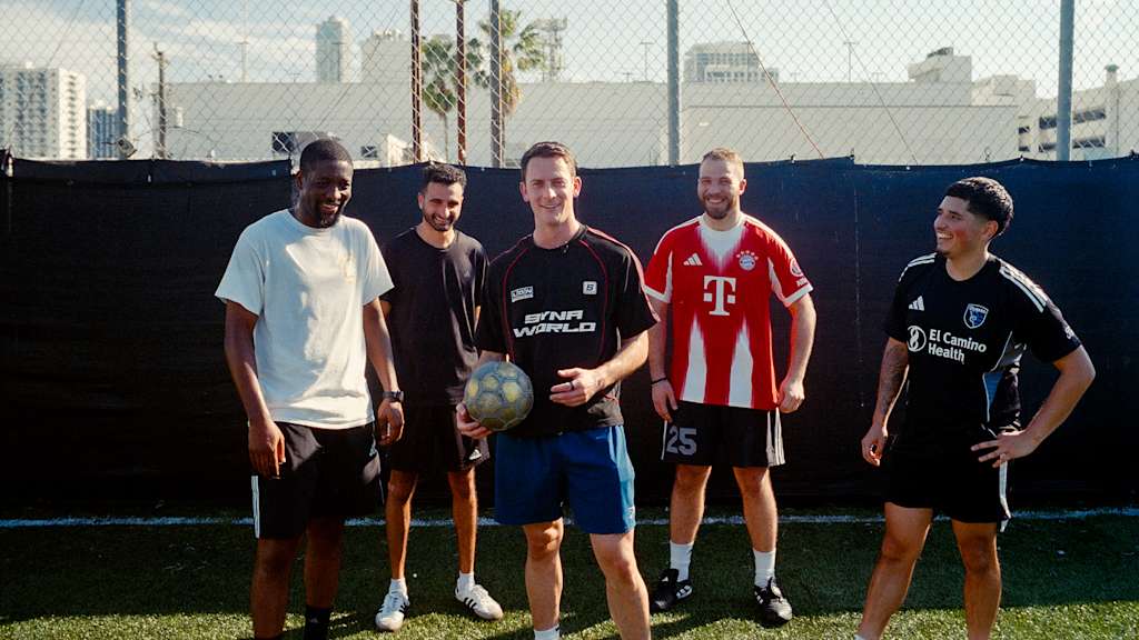 Fünf Männer stehen auf einem Fußballplatz