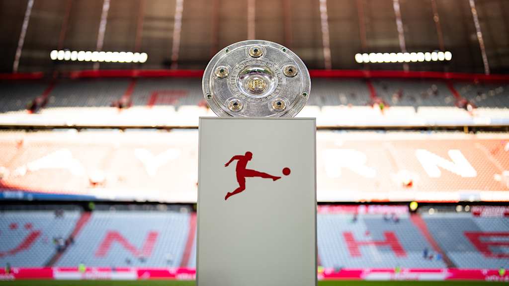 Meisterschale der Bundesliga auf einem Podest auf dem Rasen der Allianz Arena