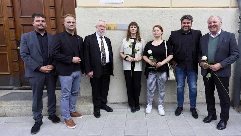 FC Bayern München eV managing director Benny Folkmann (second from left) in front of a memorial plaque at a commemorative event for victims of National Socialism