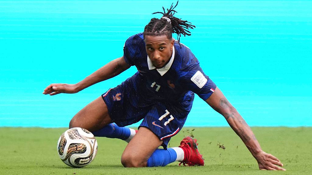 Michael Olise falls to the ground but keeps his eyes firmly on the ball