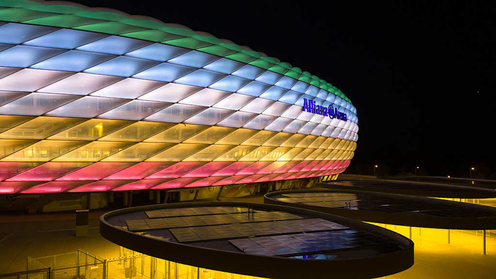 Die Allianz Arena leuchtet bei Nacht in den Farben des Disability Pride Month in Rot, Gelb, Weiß, Blau, Grün, Schwarz