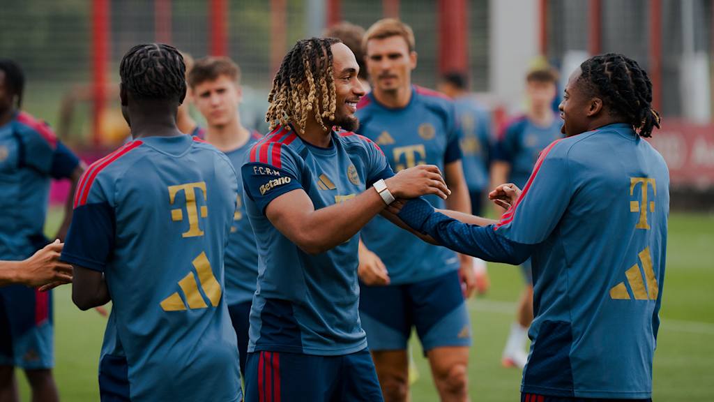 Sacha Boey flachst mit Wisdom Mike im Training des FC Bayern