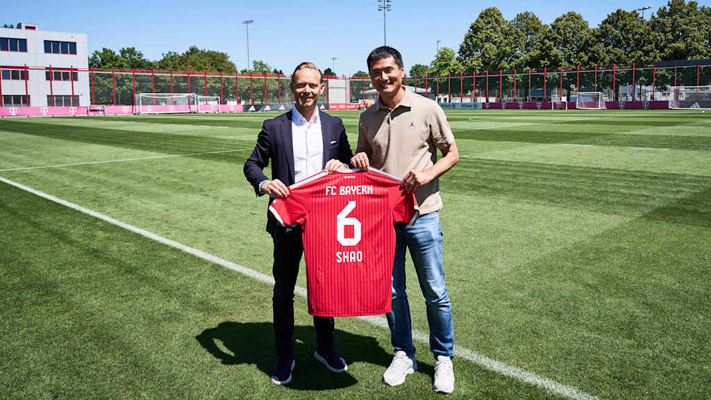 Rouven Kasper, Vorstand Marketing & Vertrieb des FC Bayern, überreicht Shao Jiayi ein Trikot des FC Bayern.