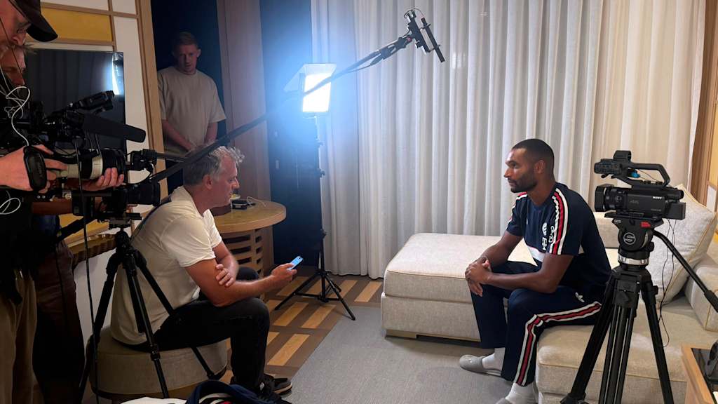 Jonathan Tah sitzt in einem Hotelzimmer und gibt ein Interview