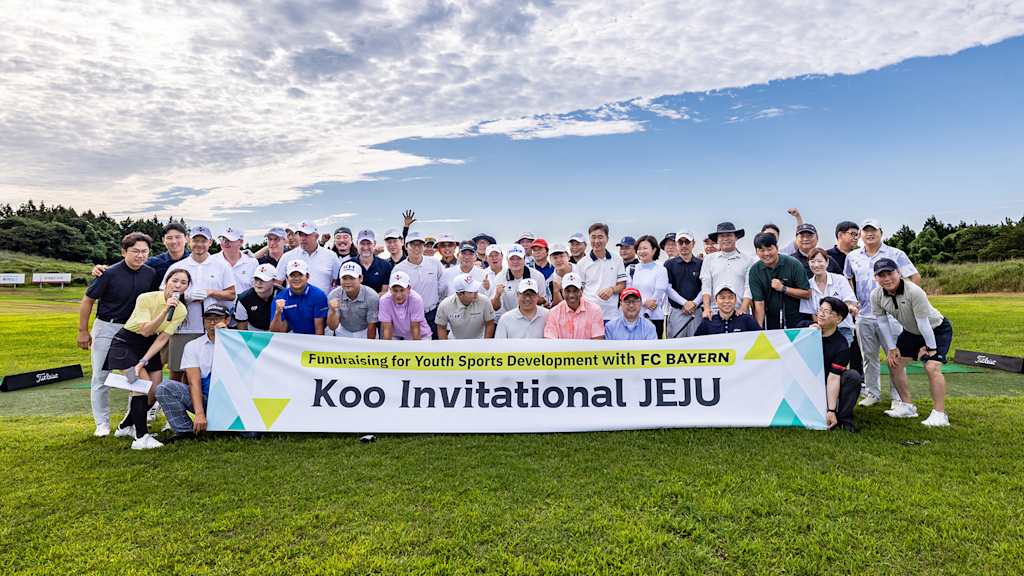 Teilnehmer eines Golf-Events des FC Bayern und des Jeju SK FC halten ein Banner
